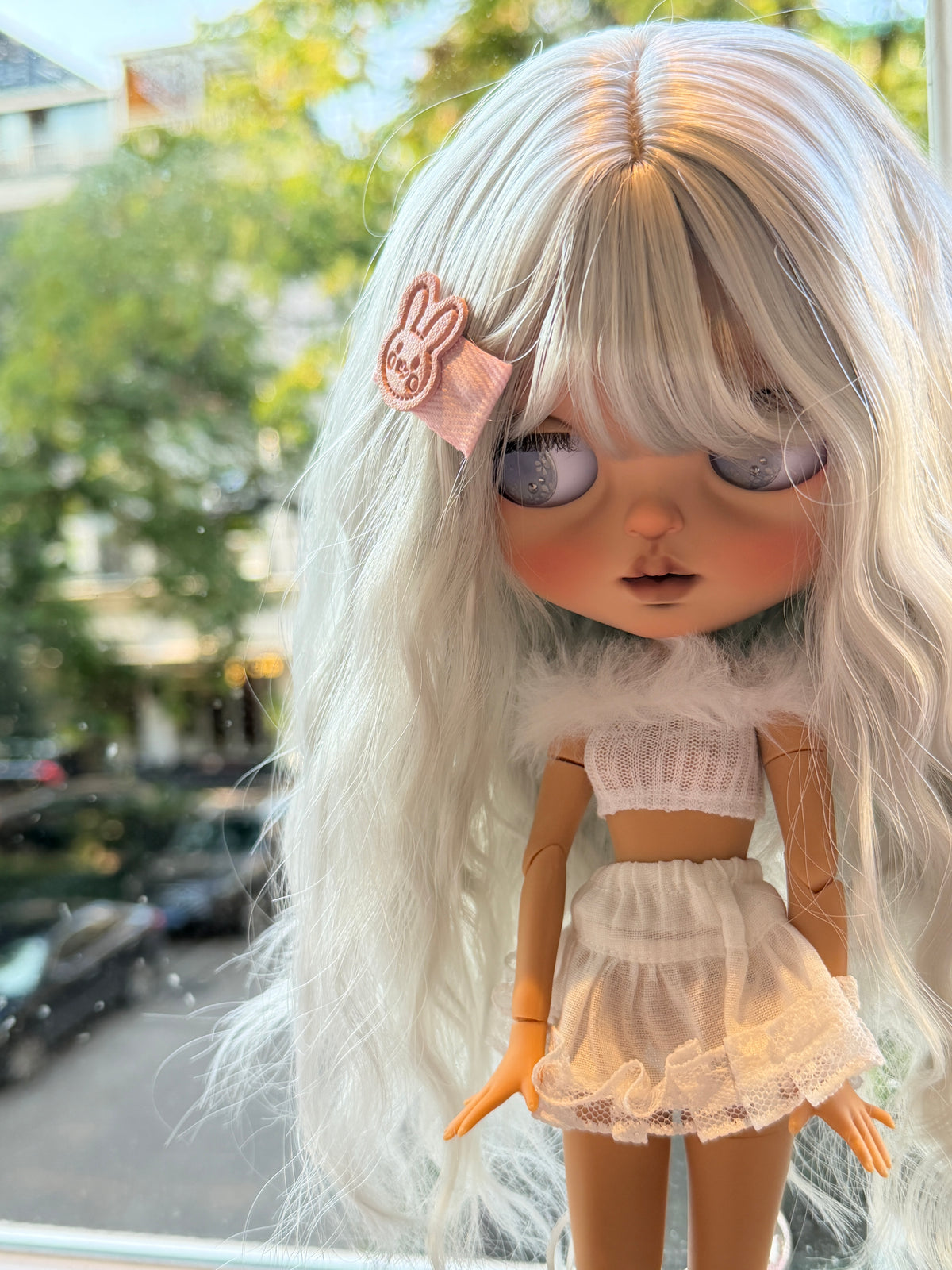 Real photo of Swan with silver-blue hair, lavender eyes, a pink hair clip and a white ballet-inspired outfit.