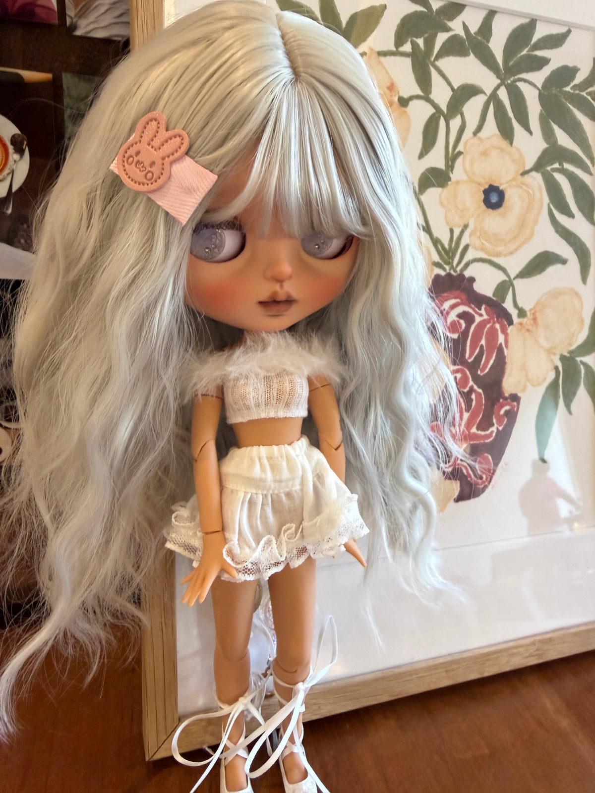 Real photo of Swan showing her face, pale lavender eye details and fluffy-trim white top.